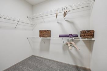 A white closet with a purple hanger and two baskets.